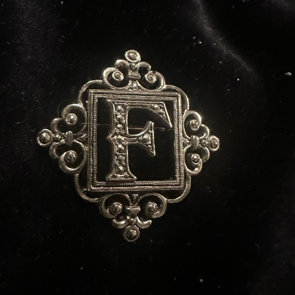 Elegant Silver Brooch with Ornate 'F' Design
